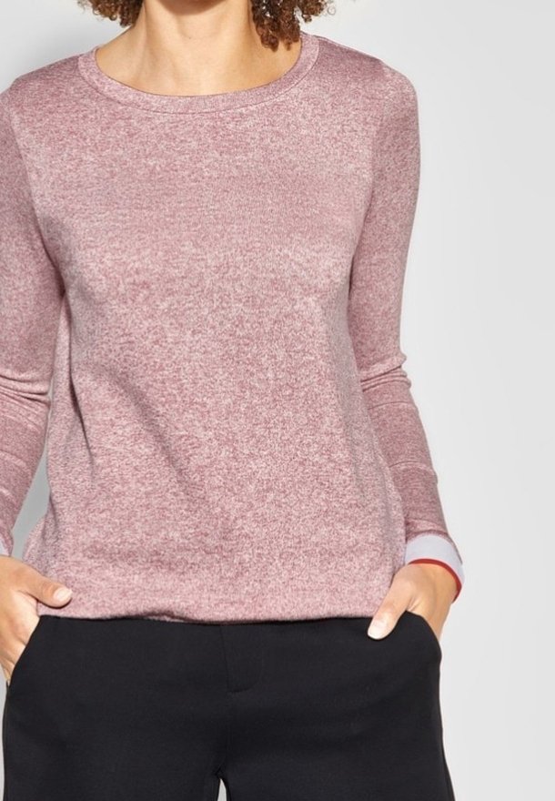 Pull long à manches longues couleur rose pâle, col rond, tricot texturé, avec des poignets blancs et rouges contrastants. Design ajusté avec un motif subtil.