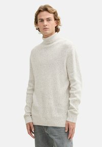 Hellbeige, geripptes Rollkragensweatshirt mit strukturierter Strickware. Lange Ärmel und lockere Passform, mit dezenten, gesprenkelten Details.