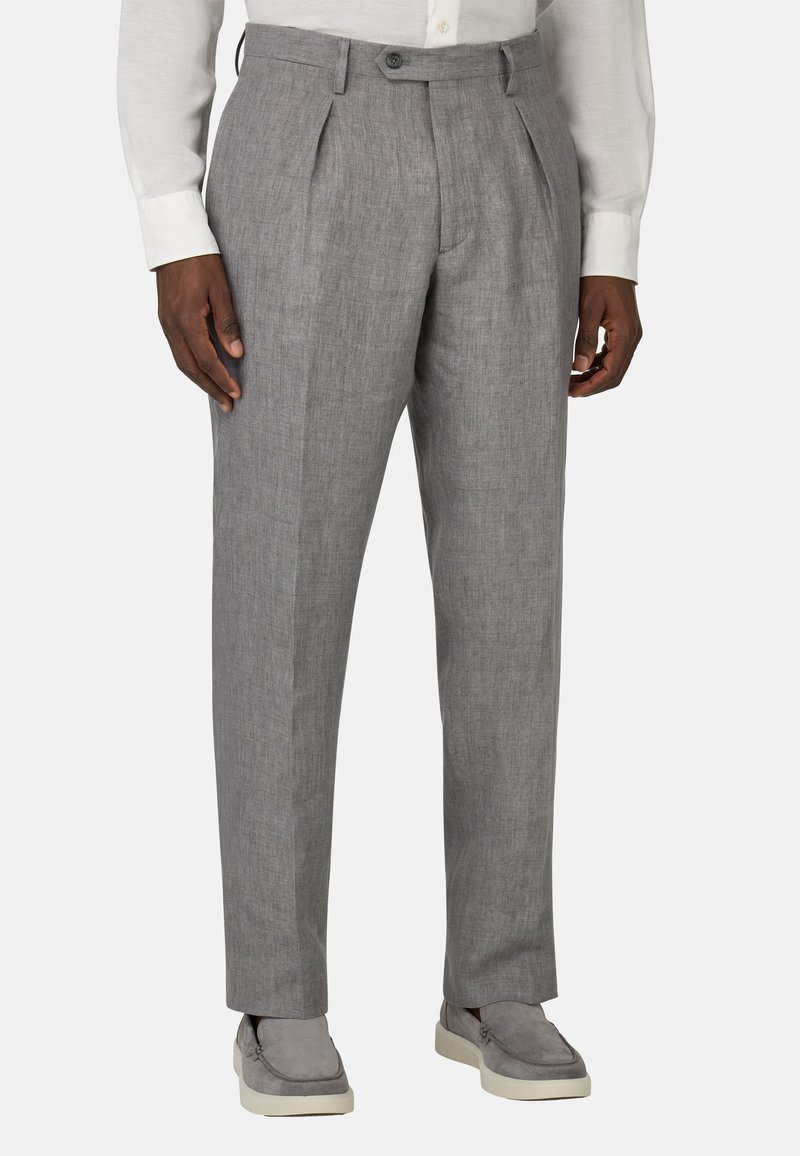 Pantalons de costume plissés gris clair en tissu texturé, dotés d'une fermeture par bouton et de poches. Assortis à des chaussures gris à enfiler.