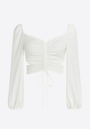 Hvid kort top med lange pufærmer, rynket frontdesign og snøre i taljen, lavet af let og glat stof.