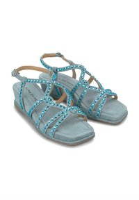 Sandali in suede blu chiaro con molte cinghie incrociate decorate con strass turchesi; punta quadrata e tacco basso a zeppa.