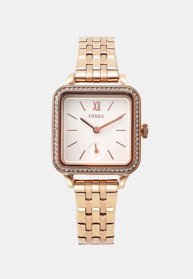 Roségoldene Fossil-Armbanduhr mit quadratischem Zifferblatt, kristallbesetzter Lünette, römischer Ziffer XII und linkem Metallarmband.