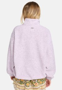 Lila fleece pullover met hoge kraag, gestructureerd oppervlak en verlaagde schouders. Opmerking: logo label zichtbaar op de achterkant.