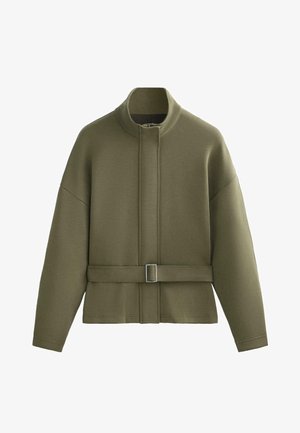 Olivno zelena jakna iz mehkega blaga, ki ima visok ovratnik, dolge rokave in pas s kovinsko zaponko.