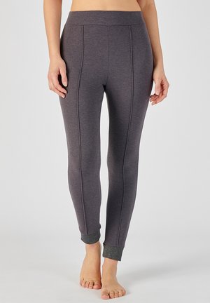 Leggings grises con una textura suave y detalles de costura. Los puños tienen un acento brillante y contraste en el dobladillo.