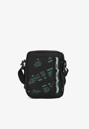 Sac bandoulière carré noir avec texte turquoise, un détail de sangle verticale turquoise et une bandoulière ajustable.