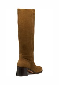 Bota de ante marrón hasta la rodilla con tacón cuadrado. Presenta una textura suave, costuras verticales y punta redondeada para un diseño elegante.