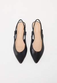 Μαύρα δερμάτινα παπούτσια slingback με μυτερή μύτη και μινιμαλιστικό σχέδιο λουριού. Μαλακή μπεζ σόλα με το όνομα της μάρκας αποτυπωμένο.
