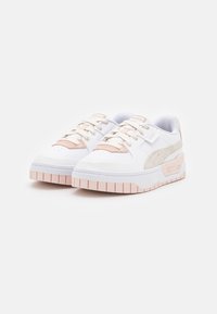 Scarpe sportive bianche con accenti rosa, realizzate in pelle e camoscio, punta arrotondata, suola in gomma spessa e caratteristiche di allacciatura prominenti.
