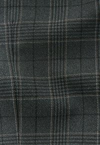 Tissu à carreaux de couleur gris foncé avec des lignes gris clair et marron. Tissage texturé avec un motif serré, adapté à la couture ou à la tapisserie.