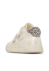 Beige Sneaker für Kinder mit Klettverschluss und Leopardenmuster-Detail an der Ferse, von hinten auf weißem Hintergrund gezeigt.
