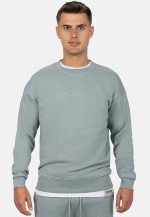 Lichtgrijze sweatshirt van zacht materiaal, met ribgebreide manchetten en zoom, ronde hals en een klein geborduurd logo op de voorkant.
