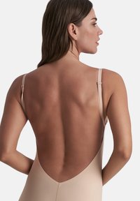 Body aderente senza cuciture con un design a schiena bassa, spalline regolabili e una texture morbida, ideale per essere indossato in sovrapposizione o da solo.