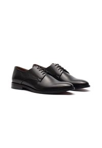 Scarpe da uomo in pelle nera con texture liscia, punta arrotondata e sei fori per i lacci. Suola piatta con minimo battistrada per un abbigliamento formale.