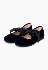 Bailarinas de terciopelo azul marino con punta redonda, corte lateral y lazos de cinta negra. Presentan un forro interior suave y suelas bajas y planas.