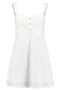 Vitt spetsklänning med figurnära midja, justerbara axelband och en rynkad mitt. Har tre dekorativa knappar framtill.