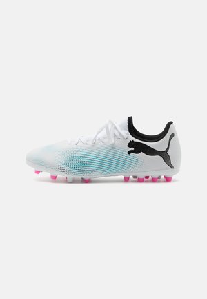 Botas de fútbol en blanco con un patrón degradado en azul, con acentos en negro y una suela rosa, diseñadas para el rendimiento y la tracción.