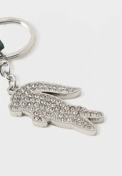 Porte-clés en argent en forme de lapin, décoré de multiples petits strass transparents, attaché à un anneau en métal.