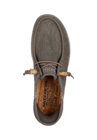 Zapatilla gris sin cordones con parte superior de tela texturizada, plantilla de corcho y un sencillo detalle de nudo en el cuello. Diseño ligero.