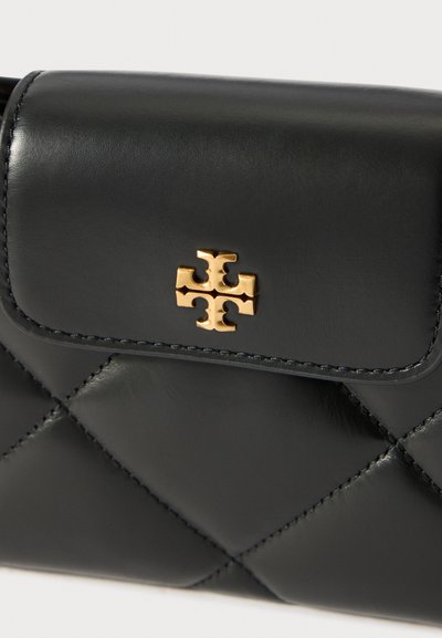 Μαύρο καπιτονέ πορτοφόλι από δέρμα με χρυσό διακοσμητικό κούμπωμα σε σχήμα σταυρού στη μπροστινήκατσα.