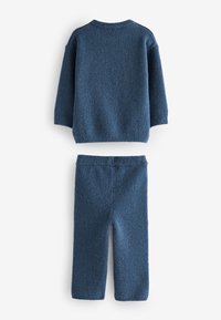 Ensemble tricoté bleu doux avec pull à manches longues et pantalon assorti, posé à plat, conçu pour la chaleur et le confort.