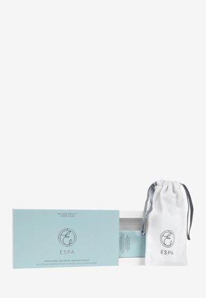 Un rouleau de massage facial en jade aventurine dans une boîte bleu clair avec un texte blanc. Comprend un pochette à cordon blanc avec le logo. Design élégant et lisse.