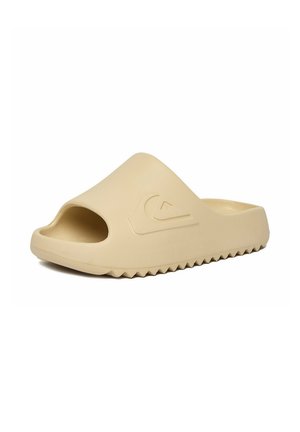 Beżowy sandał typu slip-on z odkrytym palcem, teksturowaną podeszwą i wytłoczonym falistym logo z boku, zaprojektowany do noszenia na co dzień.