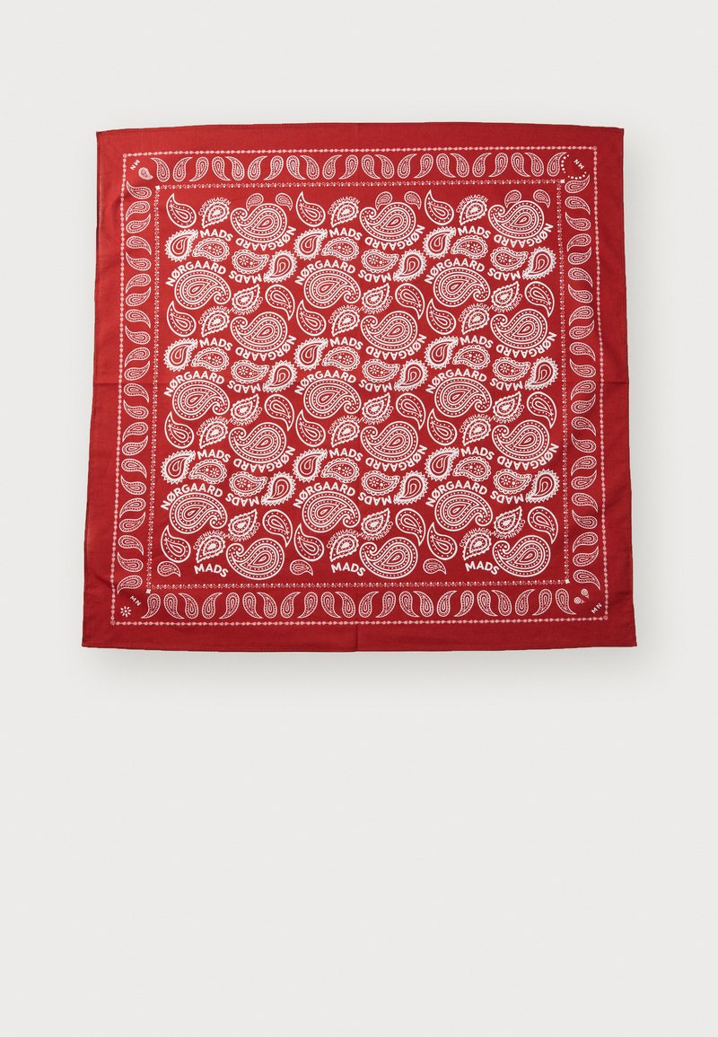 Bandana roja con patrones paisley blancos y el texto "Nørgaard Mads". Forma cuadrada con una textura de tela suave y un borde decorativo.