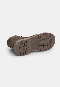 Stivale in suede marrone con suola in gomma, caratterizzato da un motivo di battistrada testurizzato per una migliore aderenza e un design a punta arrotondata, visto dal basso.