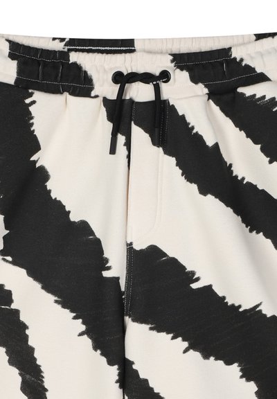 Zwart-witte gestreepte sweatpants met een elastische tailleband, koord en een voorkantzak. Gemaakt van zachte stof met een gladde textuur.