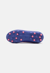 Sole di scarpa da calcio viola con numerosi tacchetti rosa per aderenza. Presenta una superficie testurizzata e un marchio lungo il lato.