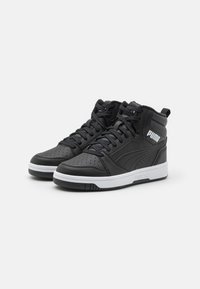 Zwarte leren high-top sneakers met geperforeerde details, witte zool en branding op de zijkant en de tong. Gegarandeerd grip.