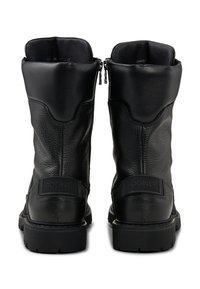 Černé kožené boty s texturovaným povrchem, výškou ke kotníku, zadními zipy a vyraženou logovou nášivkou. Tlusté gumové podrážky a zaoblené špičky.