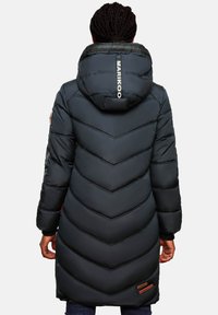 Lang gewatteerde jas in donkerblauw met een capuchon, voorzien van een chevronpatroon, zwarte accenten en een logo op de achterkant. Verstelbare manchetten.