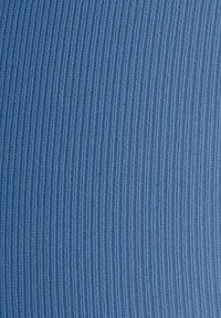 Tessuto blu a righe con superficie testurizzata e linee verticali. Il colore è uniforme, creando un aspetto liscio e continuo.
