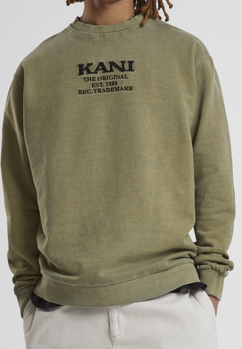 Grön sweatshirt i bomullsblandning med rund halsringning och ribbad mudd. Den har broderad varumärkestext på framsidan.