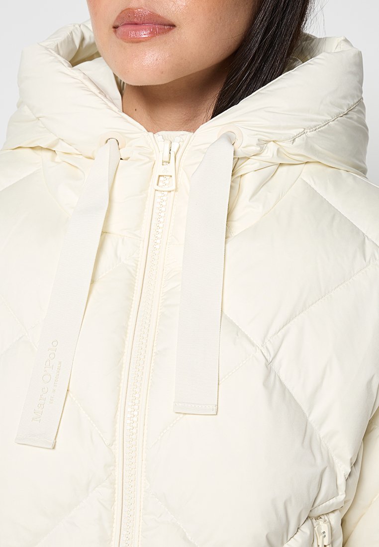 Lichtcrème gewatteerde jas met een grote capuchon, frontale rits en trekkoordaccenten. Glad, glanzend materiaal met subtiele branding.