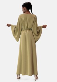 Abito maxi in tessuto verde oliva con un taglio comodo, maniche larghe e vita elastica. Texture liscia, design lungo fino al pavimento.