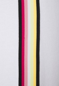 Bílá látka s vertikálním pruhovaným vzorem, který zahrnuje černé, růžové, světle růžové, světle zelené, žluté a bílé pruhy stejné šířky.