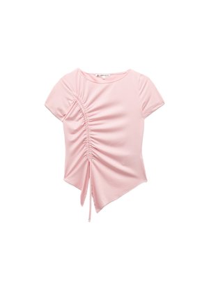 Helles rosa Kurzarmoberteil mit gerüschten Details und Bindebändern auf einer Seite, asymmetrischem Saum und rundem Ausschnitt vor weißem Hintergrund.