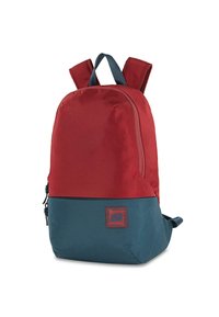Mochila de poliéster roja y azul con correas acolchadas, cremallera frontal y parche con logotipo. Textura suave con forma redondeada y correas ajustables.