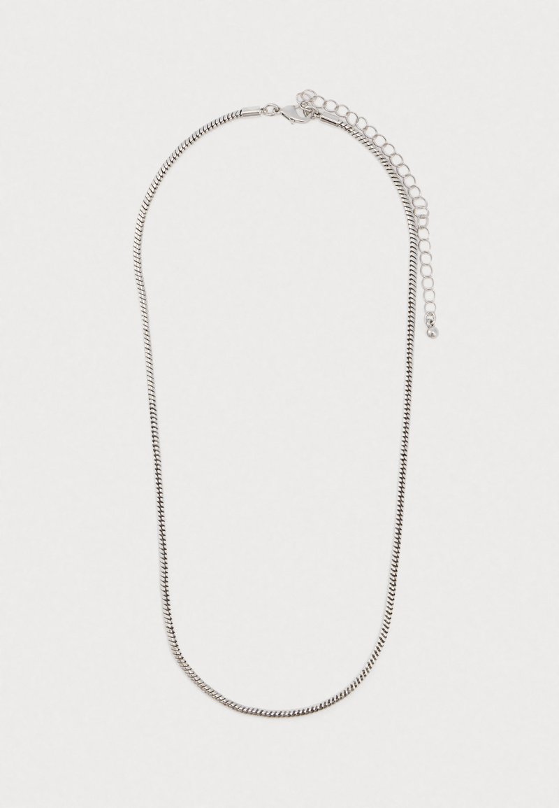 Collier en chaîne argenté avec un fermoir en forme de homard et un anneau d'extension réglable sur fond blanc.