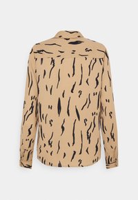 Chemise beige à manches longues avec motif abstrait en coups de pinceau noirs, col classique et poignets boutonnés, vue de dos.