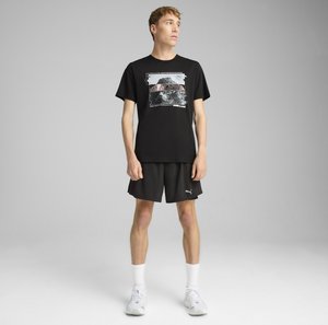 Schwarzes Baumwoll-T-Shirt mit grafikdruck, kombiniert mit schwarzen Shorts und weißen Knöchelsocken. Die Schuhe sind grau mit dezenten Designelementen.