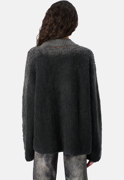 Suéter negro carbón de gran tamaño hecho de un material texturizado y suave con un cuello acanalado. Corte holgado con hombros caídos y dobladillo recto.