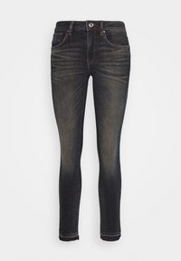 Úzké džíny v tmavé modré denimové barvě. Mají klasický pětikapsový design, zip s jedním knoflíkem na zapínání a jemné detaily oděru.