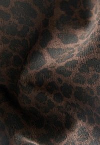 Leopard print fabric in shades of brown and black, featuring a soft texture with a slightly glossy finish.