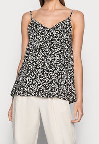 Top senza maniche nero con scollatura a V, caratterizzato da un motivo floreale bianco, silhouette fluida e spalline sottili regolabili.