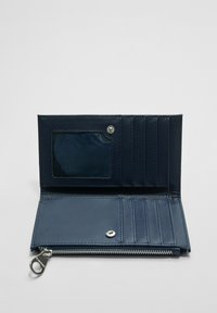 Granatowy skórzany portfel otwarty, pokazujący przezroczystą kieszeń na identyfikator, kilka kieszeni na karty, zapięcie na nap oraz zasuwaną kieszeń na monety.