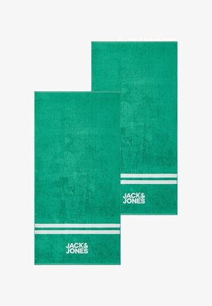 Zwei grüne rechteckige Handtücher mit weißen doppelten Streifen nahe am Rand und dem "JACK & JONES" Logo unter den Streifen gedruckt.